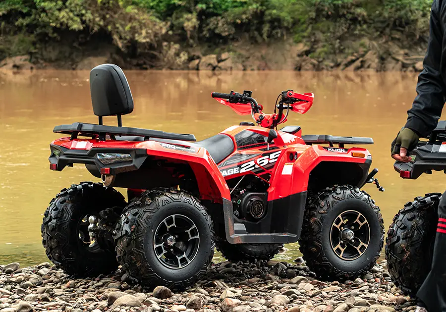 ATV RAMPAGE 265 สีแดง จอดบนหาดแม่น้ำ